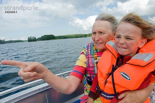 Großmutter und Enkel in Motorboot fahren