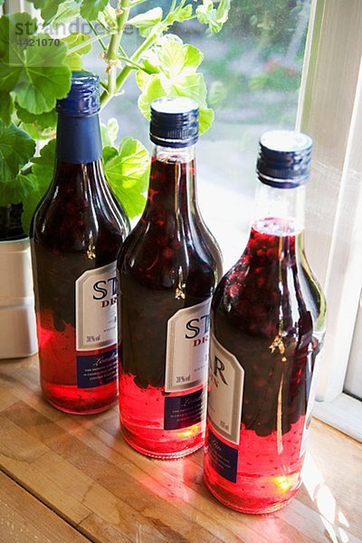 Flaschen mit Likör auf Fensterbrett