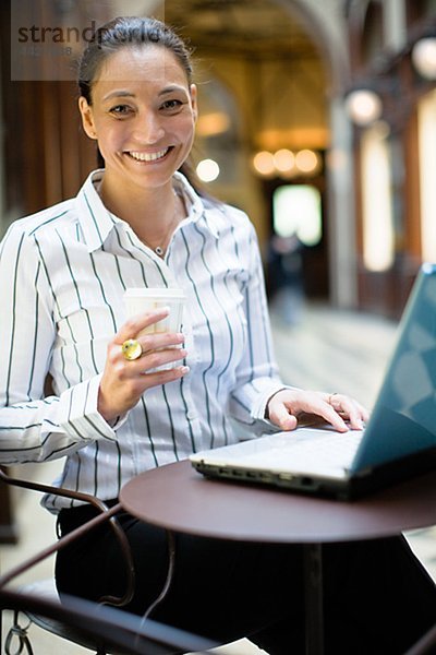 Porträt von Reifen Geschäftsfrau with Laptop  halten Kaffee zum Mitnehmen