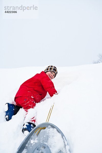 Junge spielt auf Schnee