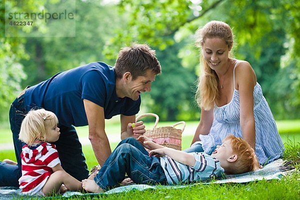 Mitte adult Eltern mit Kindern während Picknick Aufdrängend