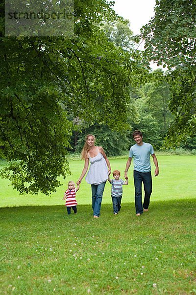 Eltern mit Kindern im Park zu Fuß