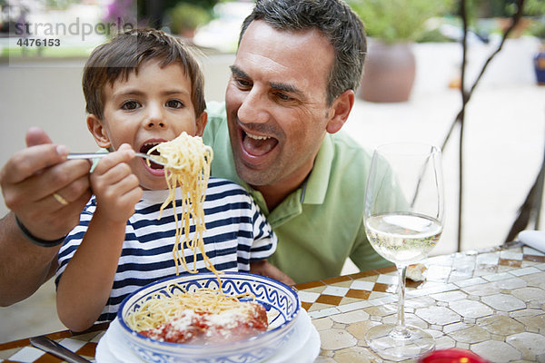 Vater und Sohn beim Spaghettiessen