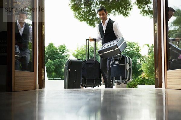 Mann mit Koffern im Hotel