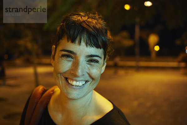 Frau bei Nacht lächelnd vor der Kamera