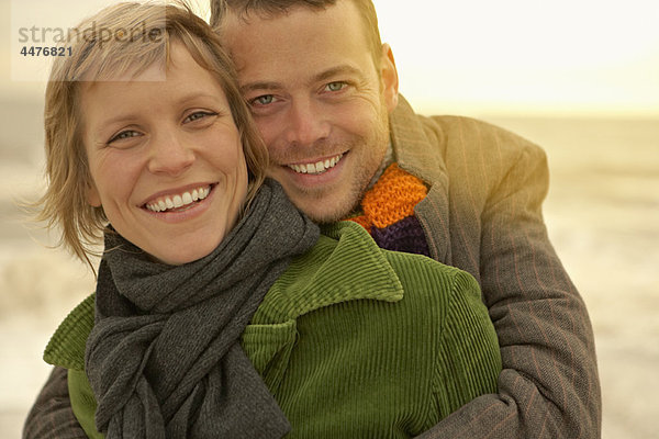 Paar  das sich am Strand umarmt Herbst Herbst