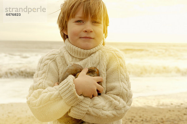 Kleiner Junge an einem Strand mit Steinen