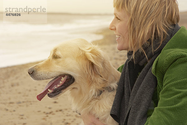 Frau und Hund am Strand