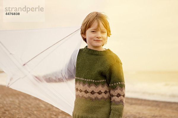 Kleiner Junge am Strand mit Drachen. Herbst