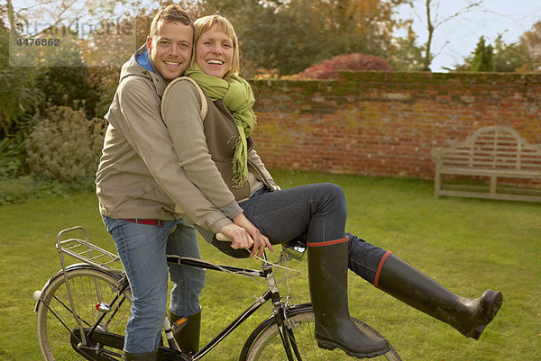 Couple on old bicycles  her on handles