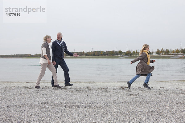 Großeltern und Mädchen beim Spaziergang am See