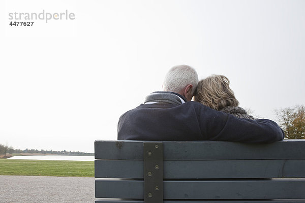 Seniorenpaar sitzt auf einer Bank im Park