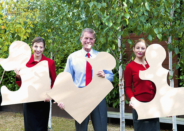 Business-Team hält Puzzleteile in der Hand