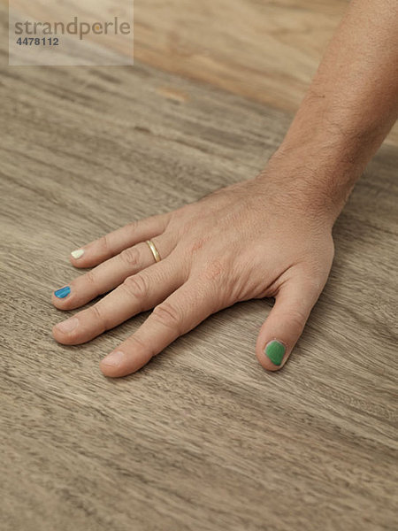 Detail der Hand eines Mannes mit bemalten Nägeln