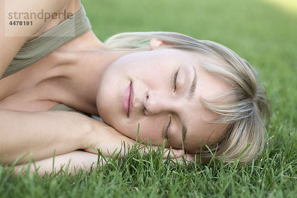 Frau auf der Seite schlafend auf Gras