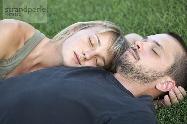 Mann und Frau schlafen auf Gras