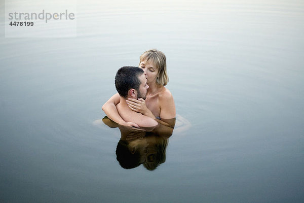 Paar im Wasser umarmend