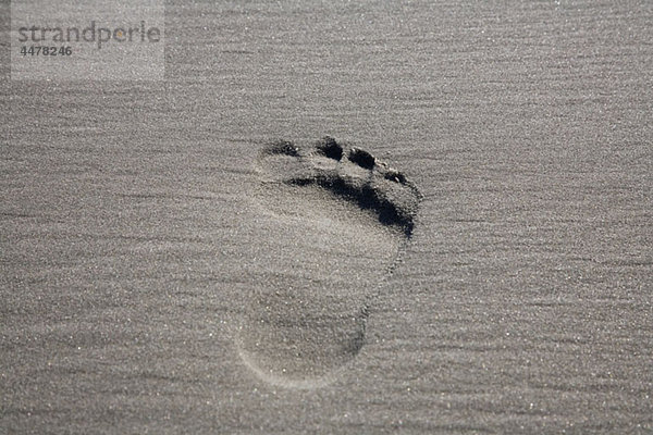 Ein einziger Fußabdruck im Sand