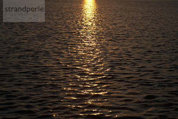 Der Sonnenuntergang auf einem gewellten Meer