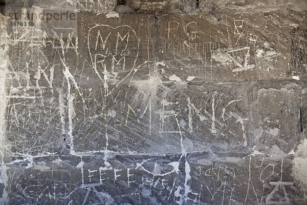 Handgeschriebenes Graffiti in eine Steinmauer geätzt