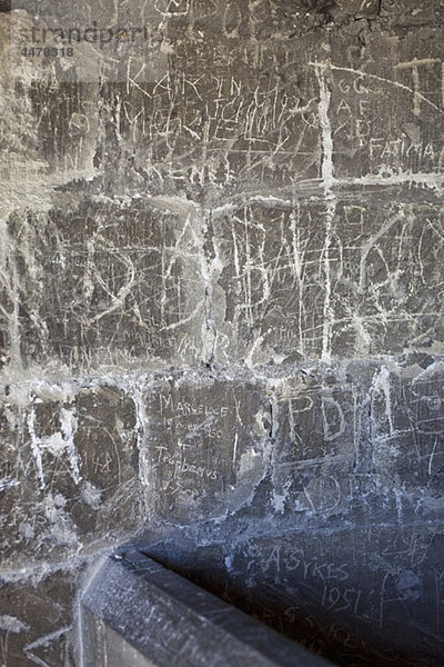 Handgeschriebenes Graffiti in eine Steinmauer geätzt