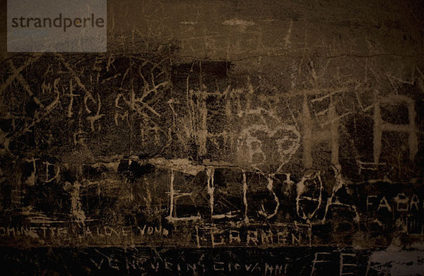 Handgeschriebenes Graffiti in eine Steinmauer geätzt