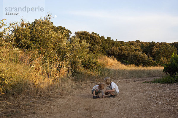 Zwei Jungen spielen auf einem Feldweg