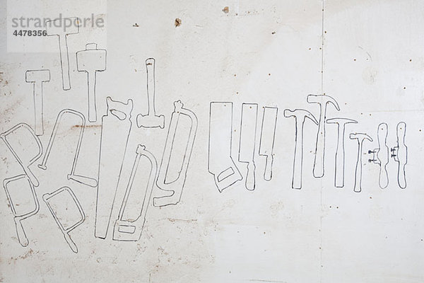 Gezeichnete Umrisse von Handwerkzeugen an einer Wand