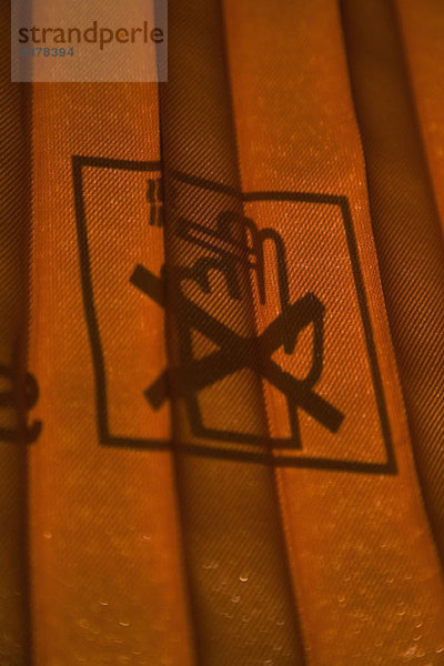 Detail eines geschlossenen Vorhangs und eines Nichtraucherzeichens