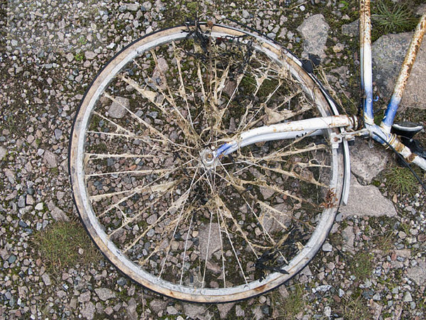 Teil eines alten Fahrrads  das auf dem Boden liegt.