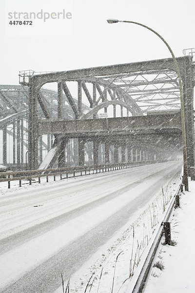 Ein Schneesturm über eine Straßenbrücke