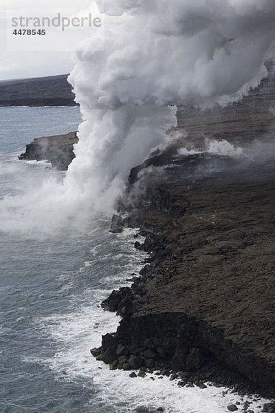 Dampf vom Vulkan  der in das hawaiianische Meer fließt.