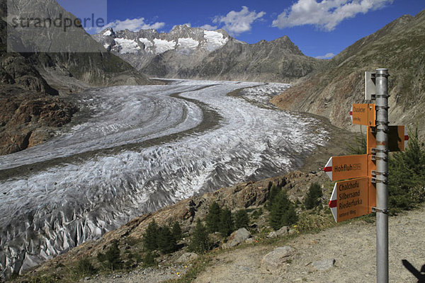 Ein Wegweiser neben einem Gletscher in den Schweizer Alpen