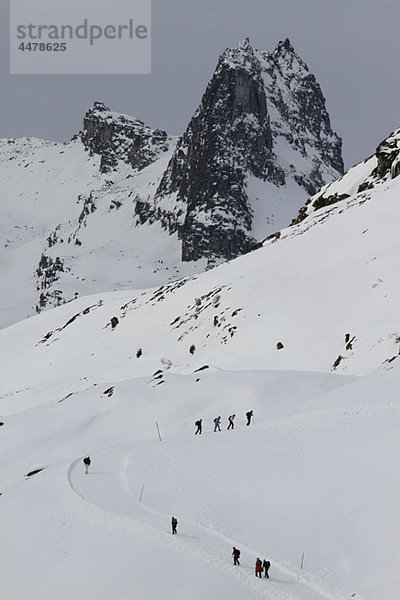 Menschen wandern auf einem verschneiten Bergwanderweg