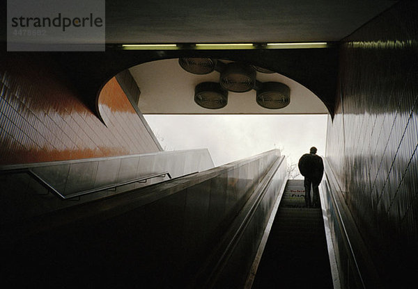 Niederwinkelansicht eines Mannes auf einer U-Bahn-Rolltreppe