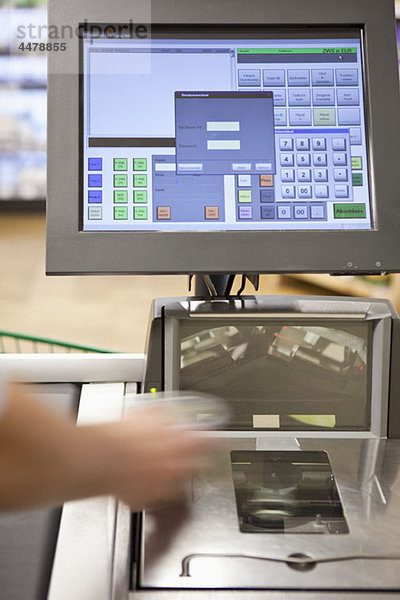 Eine Kassiererin scannt Lebensmittel in einem Supermarkt.