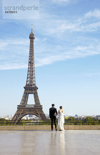 Ein junges Ehepaar vor dem Eiffelturm  Paris  Frankreich