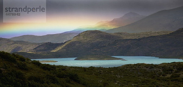 Blick auf einen Regenbogen über Berge und See  Torres del Paine Nationalpark  Chile