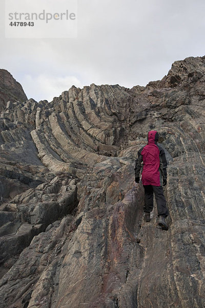 Rückansicht einer Frau beim Aufstieg auf einen felsigen Berg  Torres del Paine Nationalpark  Chile