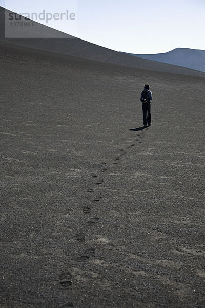 Rückansicht einer Frau  die über den Vulkan Lonquimay  Patagonien  Chile läuft.