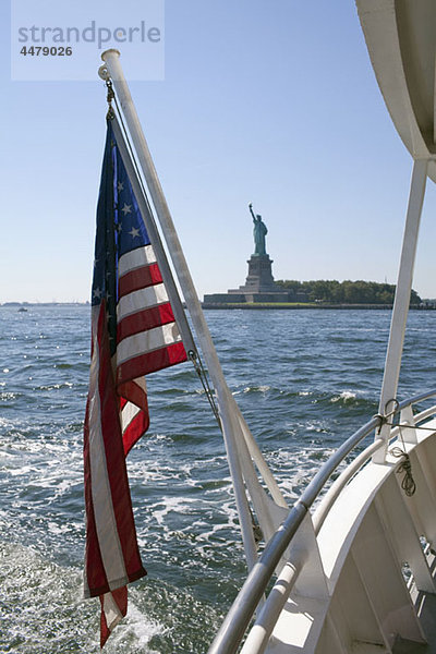 Amerikanische Flagge auf einer Fähre  Freiheitsstatue im Hintergrund