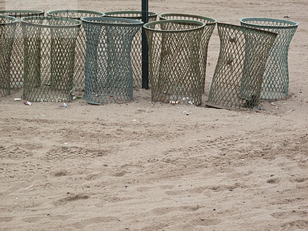 Mülleimer in einer Reihe am Strand