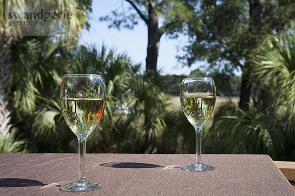 Zwei Gläser Weißwein auf einem Tisch  im Freien