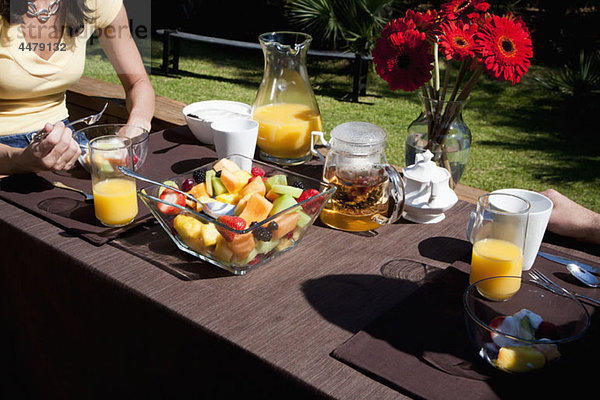 Ein Paar beim gemeinsamen Frühstück auf einem Hinterhofdeck  Mittelteil