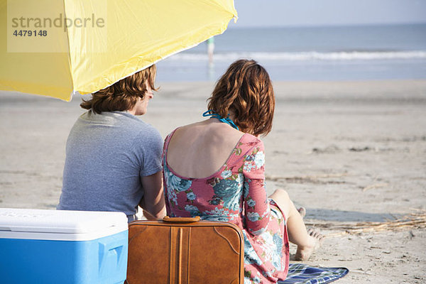 Ein junges Paar am Strand  Rückansicht