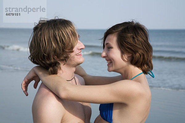 Ein junges  liebevolles Paar  das am Strand lacht.