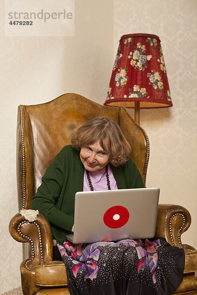 Eine ältere Frau mit einem Laptop