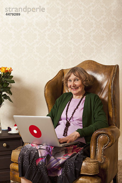 Eine glückliche ältere Frau mit einem Laptop