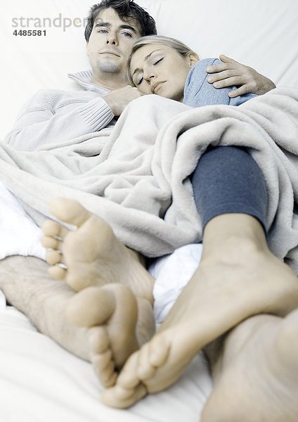 Junges Paar liegt im Bett