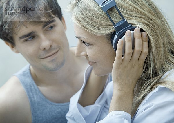 Junges Paar hört Musik mit Kopfhörern